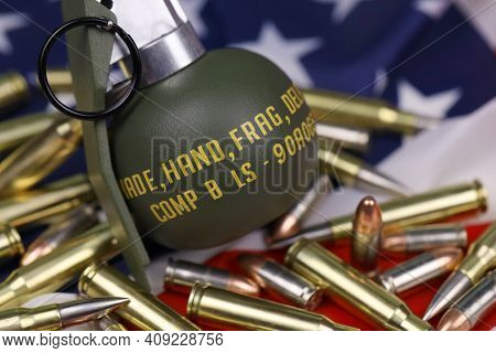 M67 Frag Grenade And Many Yellow Bullets And Cartridges On United States Flag. Concept Of Gun Traffi