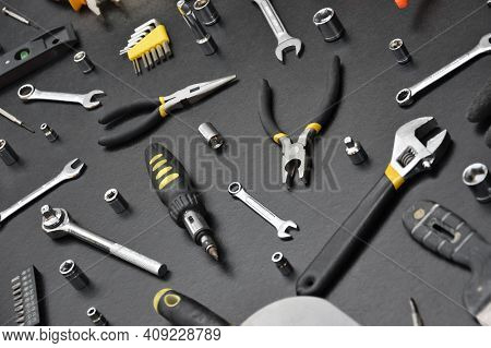 Handyman Tool Kit On Black Wooden Table. Many Wrenches And Screwdrivers, Pilers And Other Tools For 