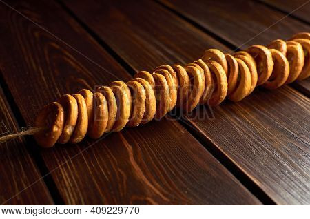 Traditional Russian Bagels On A Rope On Dark Wooden Table