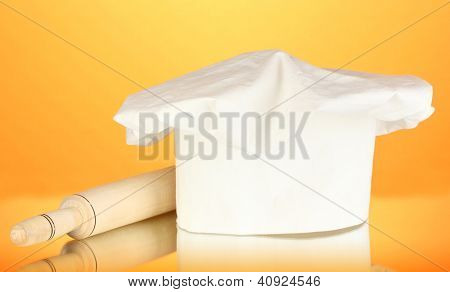 Kochmütze mit Federballschläger auf orange Hintergrund