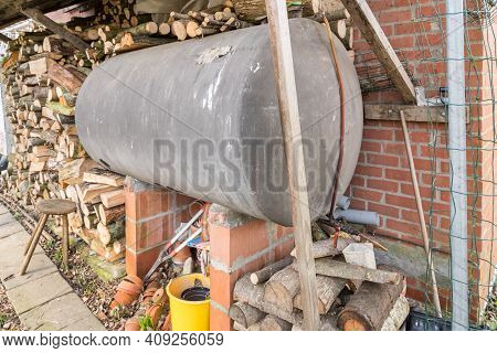 In Addition To The Facade, There Is A Fuel Oil Tank And Piles Of Wood