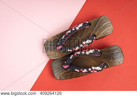 Japanese Traditional Geta Sandal On Red, Pink Background. Traditional Japanese Asian Wood Footwear C