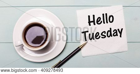 On A Light Blue Wooden Tray, There Is A White Cup Of Coffee, A Handle And A Napkin That Says Hello T