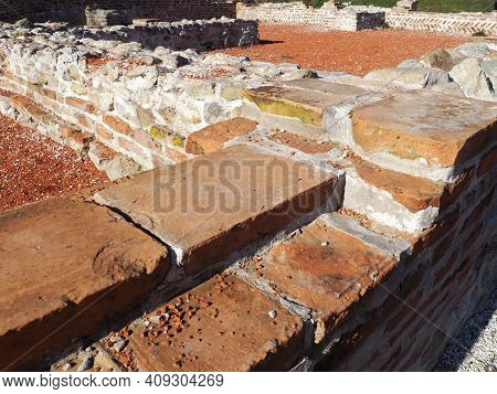 Old Roman Brick. The Restored Wall Of The Building Of Roman Times. Morning Sunlight And Warm Brown-r