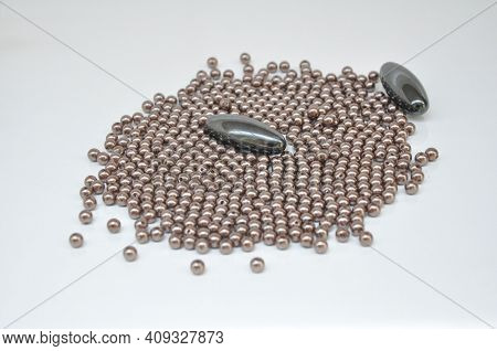 Magnet, Two Oval Magnet With Bijouteral Balls Beside On White Background With Selective Focu