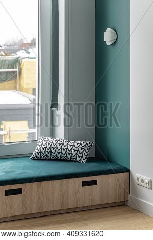 Green Sill With Cushion And Wooden Drawers.