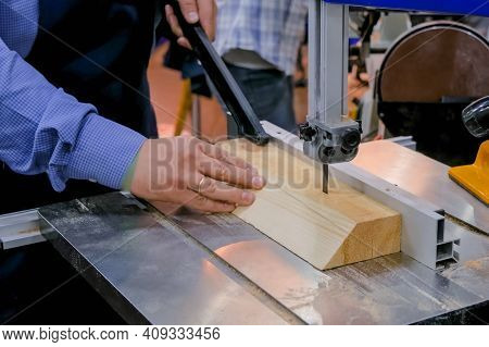 Professional Man Carpenter Hands Using Electric Bandsaw Tool, Cutting Piece Of Wood At Workshop - Cl