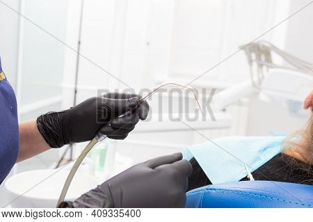 Dental Assistant Helping With Saliva Ejector During Dentist Treatment