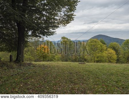 Meadow With Autumn Colorful Forest, Trees And Hills, Moody Sky. Landscape In Luzicke Hory Lusatian M