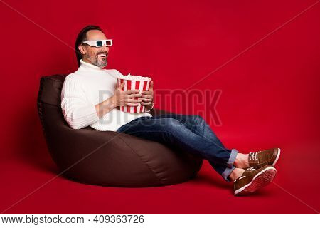 Full Size Photo Of Mature Excited Good Mood Man Sit Armchair Watch 3d Film Eat Pop Corn Isolated On 
