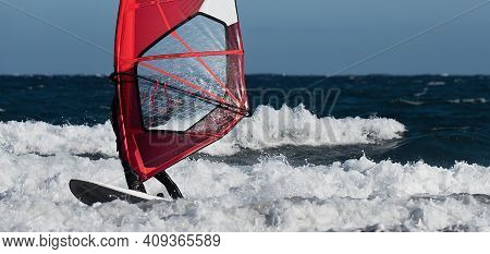 Windsurfer Surfing The Wind On Waves In Ocean Sea