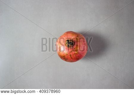 Red Garnet In The Center Of The Photo On A Gray Background. Minimalism