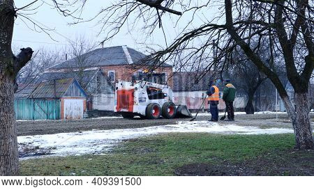 Maikop, Republic Of Adygea, Russia - January 16, 2021: A White Mini Loader Levels Gravel With A Buck