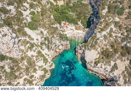 Aerial View Of Tourists Sunbath Swim At Stiniva Cove Beach Of Adriatic Sea On Vis Island In Croatia 
