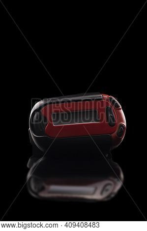 Retro Red Pager Captured Isolated On Black Background And Reflective Surface