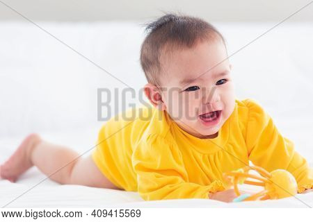 Portrait Of Beautiful Young Asian Newborn Little Baby Prone On The Bed At Home, Happy Baby Smile Wea