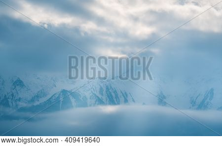 Mountain Peaks Covered With Snow Between Fog Clouds With Bright Sunrays Shining Through, Mieminger P