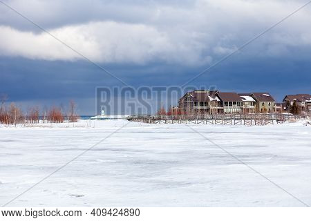 An Old, Wooden Bridge Crosses A Section Of Frozen Georgian Bay Waterfront In Collingwood, Ontario. T