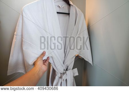 Close Up Woman Hand Choose Bath Robe From The Closet After Shower