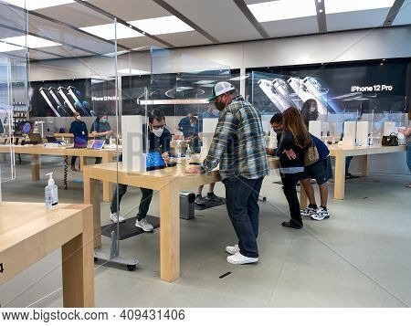 Apple Employees Waiting On Customers With Plexiglass Sheilds Between While Wearing Face Masks Due To
