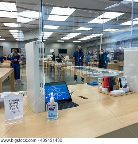 Apple Employees Waiting On Customers With Plexiglass Sheilds Between While Wearing Face Masks Due To