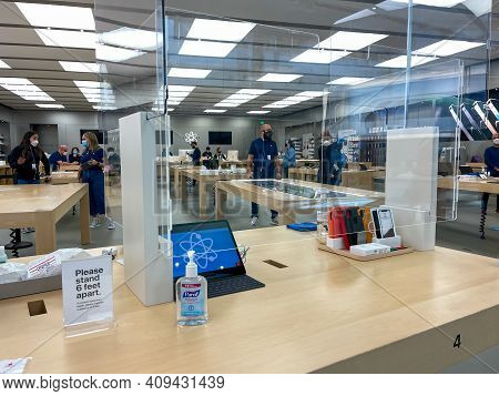 Apple Employees Waiting On Customers With Plexiglass Sheilds Between While Wearing Face Masks Due To