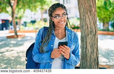 Young african american student woman smiling happy using smartphone at the university campus