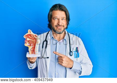 Middle age handsome otologist doctor man holding medical model smiling happy pointing with hand and finger 