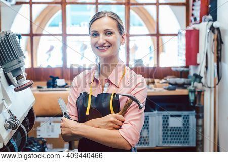 Business portrait of proud owner in her small cobbler workshop