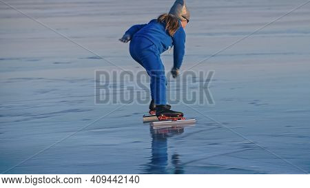 The Child Train On Ice Professional Speed Skating. The Girl Skates In The Winter In Sportswear, Spor