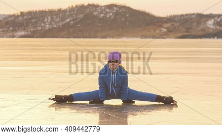 The Child Train On Ice Speed Skating. The Athlete Stretches, Warms Up, Rest. The Kid Girl Skates In 