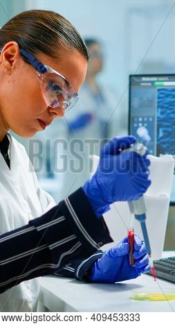 Research Scientist Using Micropipette To Extract Blood Sample On Petri Dish Analysing Chemical React