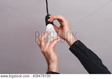 Male Hands Screw An Led Light Bulb In Holder