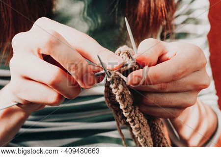 Female Hands Knitting With Beige Wool. Close-up Of Woman Knits Scarf, Sweater, Socks Or Mittens. Pro