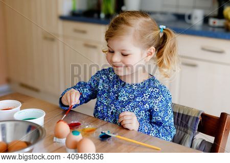 Excited Little Toddler Girl Coloring Eggs For Easter. Cute Happy Child Looking Surprised At Colorful