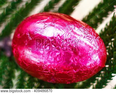 Chocolate Egg With Gold Foil On A Green Background For Easter Holiday