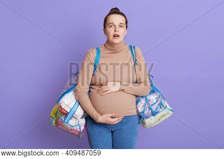 Pregnant Woman With Shocked Facial Expression, Being In Panic And Worried, Touching Her Big Belly, F