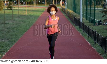 Sporty Little Girl In Face Mask Running In Park