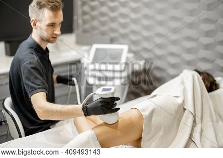 Doctor Doing Ultrasound Liposuction Procedure In Medical Clinic.