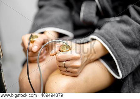 Woman Takes Hold Of The Brass Handpieces Of Bioenergetic Testing Device