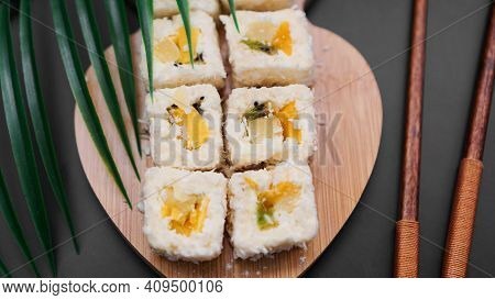 Dessert Sushi. Sweet Kiwi, Pineapple Sushi Rolls. Sushi On A Wooden Tray On A Black Background With 