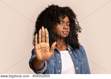 Privacy, Intimacy Concept. Black Curly Woman Showing Her Palm Over Grey Studio Background. Young Afr