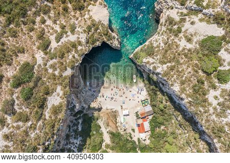 Aerial Overhead Drone Shot Of Tourists Swim Sunbath At Stiniva Beach On Vis Island In Croatia Summer