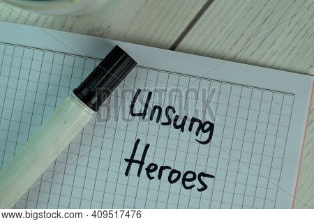 Unsung Heroes Write On Sticky Notes Isolated On Wooden Table.