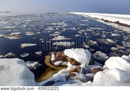 Icy Road To The Lighthouse On Mangalsala Pier In Baltic Sea Located At Riga Sea Port, Latvia, Europe
