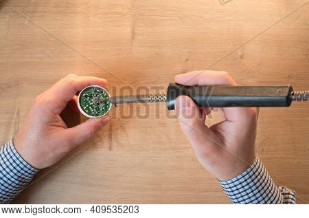 Man Repairing A Led Lamp With A Soldering Iron
