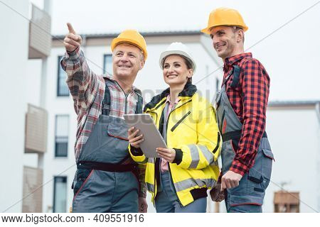 Builder and contractor inspecting new houses and residential buildings on construction site