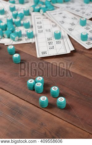 Many Barrels With Numbers And Cards For Lotto Or Russian Bingo Table Game On Wooden Surface. Russian