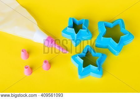 Star Shaped Cookie Cutters. Cake Decorating Tools, Pastry Bag With Nozzles On A Yellow Background Fo