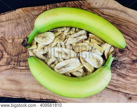 Some Dried Banana Chips On Olive Wood